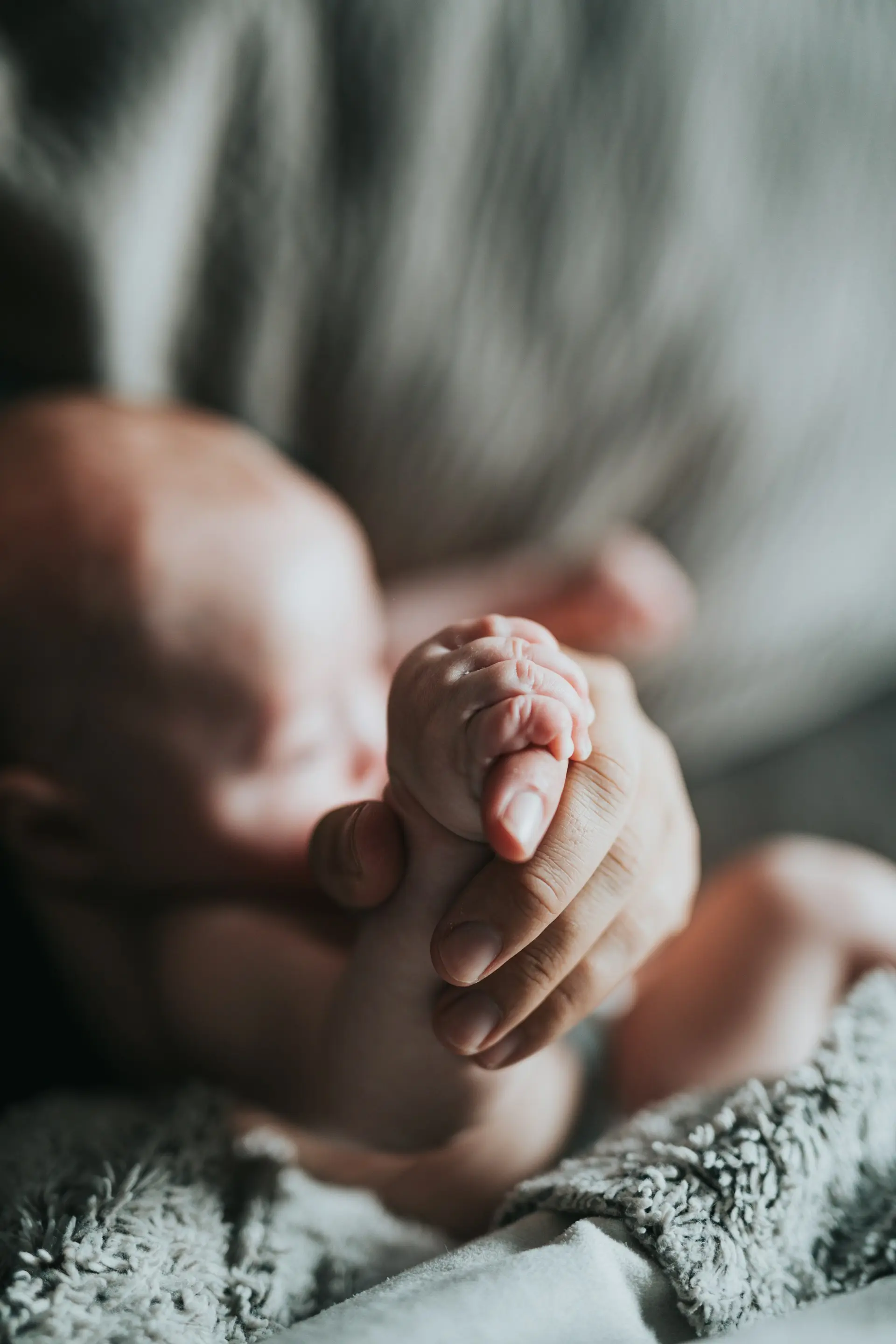 Des gestes pleins de douceurs et d'amour entre une maman et son bébé, main dans la main.